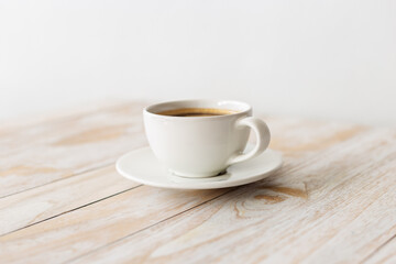 white coffee cup on wooden table with morning light