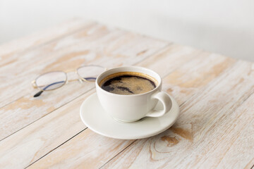 white coffee cup on wooden table with morning light