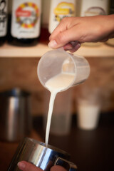 barista in a coffee shop pours milk into a jug
