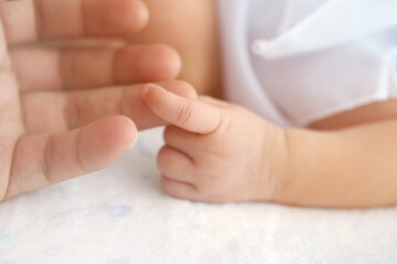 Fototapeta na wymiar Newborn baby hand with father hand