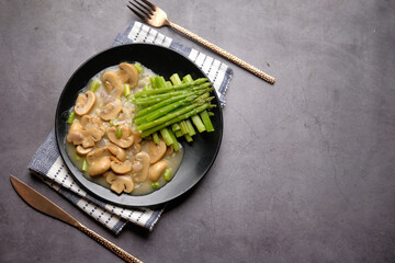 Asparagus green, olive oil and mushroom on plate black background 