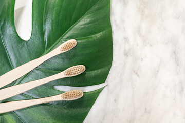 Bamboo toothbrush on a table with copy space on a marble background. Styled composition of flat lay...