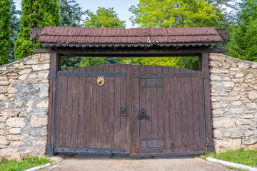 Retro countryside wooden gate with with stone wall in vintage style, close up