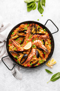 Seafood paella ready to eat served in a paella pan, top-down view