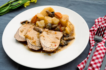Homemade a Pork Loin with potatoes and mushrooms in sauce to the saucepan of long or slow cooking. Homemade food concept, healthy and natural food, slow cooking. Normal view