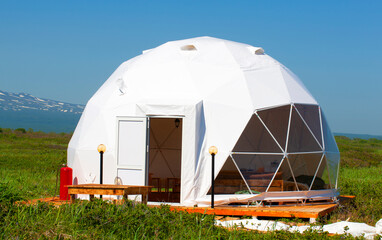 white geodome tent. Cozy glamping, holiday, vacation lifestyle concept.