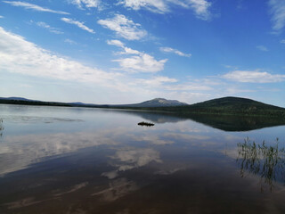 Fototapeta na wymiar Mountains and the sky are reflected in a lake