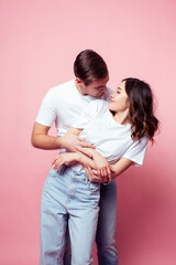 young cheerful caucasian couple together having fun on pink background, guy ang girl modern relationship, lifestyle people concept