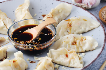 A plate of boiled jiaozi with dipping sauce