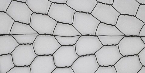 Close-up of hexagonal chicken wire against white background