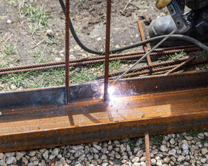 A welder welds metal at a construction site.