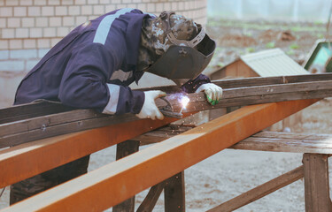 A worker welds metal at a construction site.