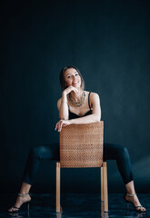 Beautiful woman sits on chair and looks into the camera