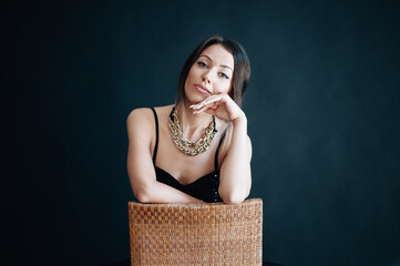 Beautiful woman sits on chair and looks into the camera