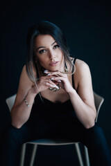 Beautiful woman sits on chair and looks into the camera