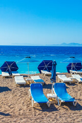 blue sun loungers at turquoise waters Elli beach Rhodes Greece.
