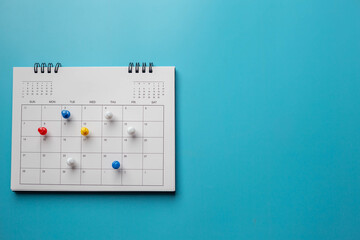 Calendar on solid ิblue background with copy space, pinned in a calender on datebusiness meeting...