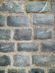 Texture of dark gray granite paving stones, top view. Background from natural block stone.