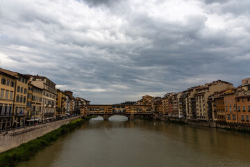 Ponte Vecchio, old bridge on the river in Florence with dramatic sky