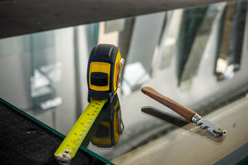 A glass cutter and a ruler lying on the glass pane at the Glass Factory