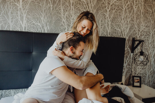 Happy couple hugging on bed