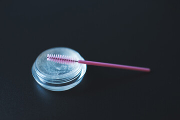 Eye brows gel glue with pink brush closeup. Make up cosmetic product. 