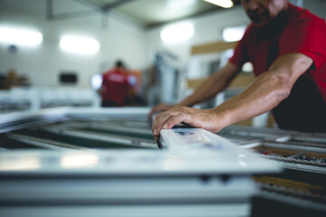 Manual worker assembling PVC doors and windows. Factory for aluminum and PVC windows and doors production.