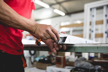 Manual worker assembling PVC doors and windows. Factory for aluminum and PVC windows and doors...