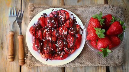 Strawberries with chocolate on a plate. Fresh juicy strawberries. Summer healthy dessert.