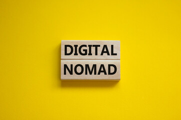 Digital nomad symbol. Wooden blocks with words Digital nomad on beautiful yellow background, copy space. Business and digital nomad concept.