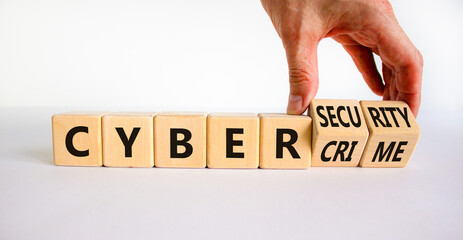 Cyber-security vs cybercrime symbol. Businessman turns wooden cubes, changes words Cybercrime to cyber-security. Beautiful white background. Cyber-security vs cybercrime concept. Copy space.