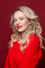 Happy woman with perfect makeup smiling on red background