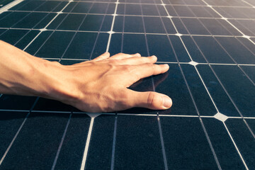 Man hand touching solar panels on sun