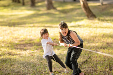 Children playing tug of war at the park on sunsut