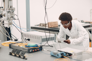 Scientist african american woman work in laboratory with electronic tech single photon detector. Research and development of electronic devices by color black woman.