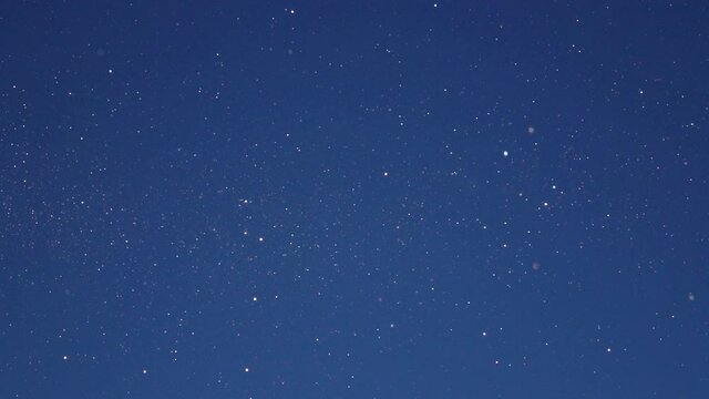 SLOW MOTION, CLOSE UP, DOF: Tiny specks of diamond dust shimmer in the bright winter sunshine. Scenic shot of the glittering diamond dust on sunny winter day. Frozen snowflakes fall from the blue sky.