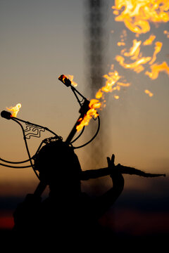 Fire-eater artist performing spit fire at sunset