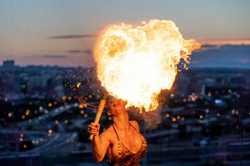 Fire-eater artist performing spit fire at sunset