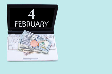 Fototapeta na wymiar Laptop with the date of 4 february and cryptocurrency Bitcoin, dollars on a blue background. Buy or sell cryptocurrency. Stock market concept.