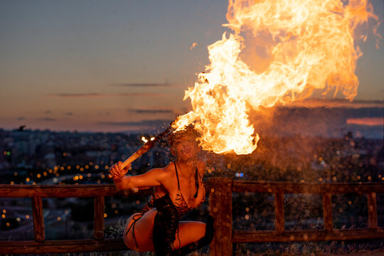 Fire-eater artist performing spit fire at sunset