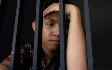 expression of man holding bars in prison