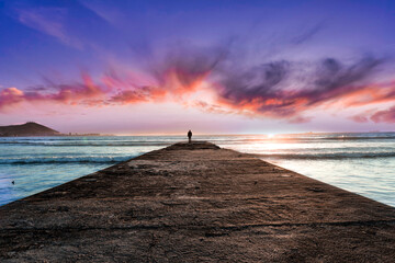 Picturesque and colourful sunset as a long jetty reaches out to the cool, blue Atlantic Ocean