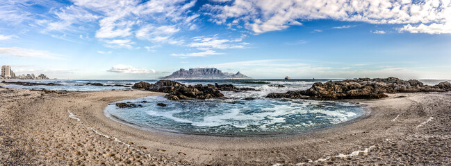 Scenic vista of Table Mountain, Cape Town, South Africa. A stunning view from Table View beach - across the bay where tourists and surfers alike come to enjoy the beach and ocean.