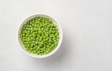 Fresh green peas in a white thicket on a gray background with space for copying.
