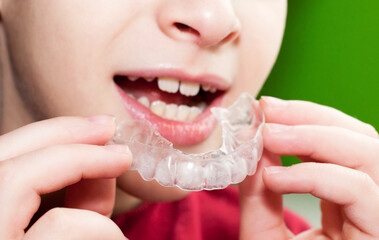 The child wears a mouth guard, straight teeth