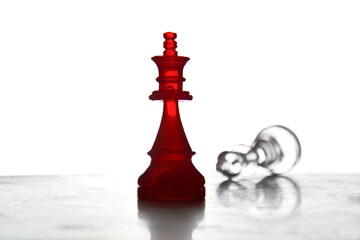 Red chess king standing over fallen crystal rival