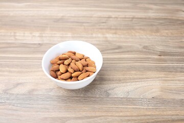 A bowl of almond nut isolated on the wooden table 