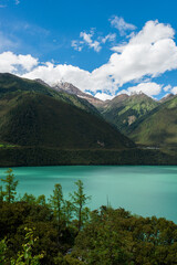 Fototapeta na wymiar Crystal Clear Glacial Water and Snowy Peaks at Pagsum Lake in Nyingchi, Tibet Autonomous Region