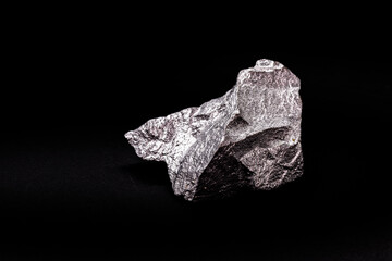 raw zinc nugget on isolated black background, metal used in alloy and steel production