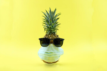Pineapple with sun glasses and mask